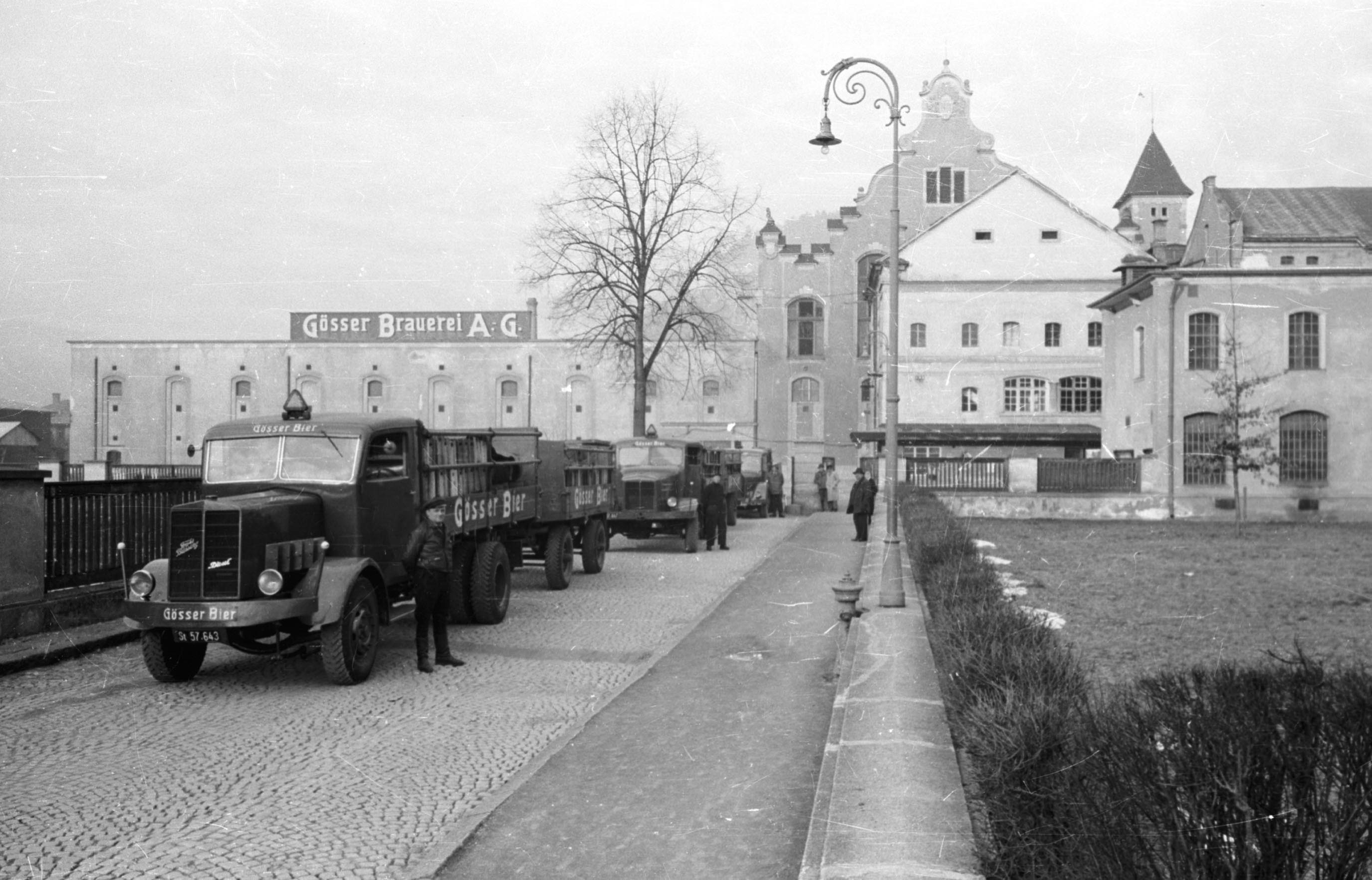 Historic delivery trucks labeled ‘Gösser Bier’ parked in front of the Gösser brewery building.
