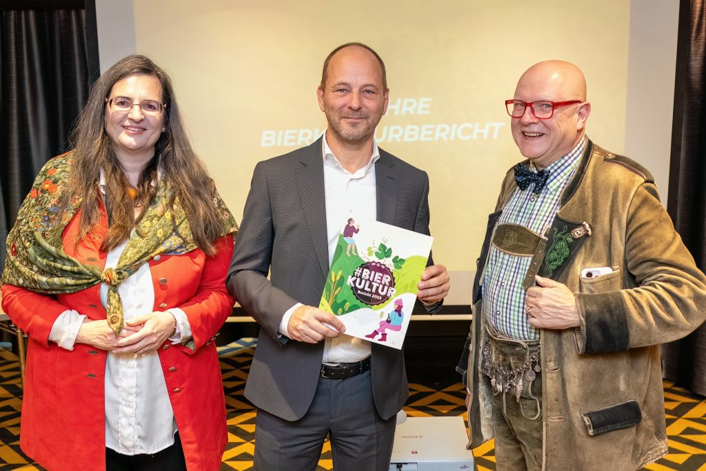 Ein Gruppenfoto mit dem Bierkulturbericht 2023 in der Hand